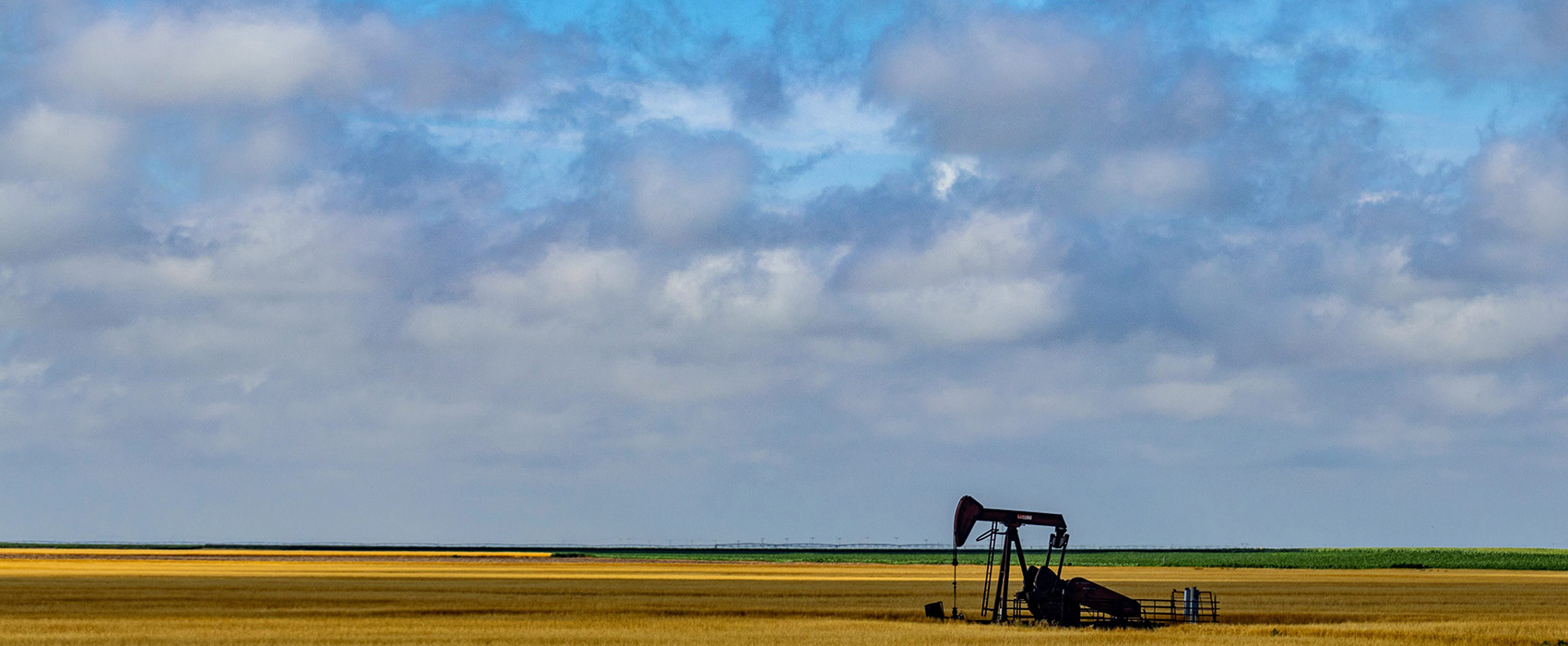 Kansas prairie landscape with pumpjack under blue sky